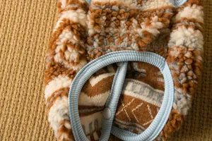 Dettaglio ravvicinato di un morbido gilet invernale per cani in pile con bottone a pressione.