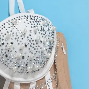 Close-up detail of white dress with shimmering rhinestones and elegant pearls.