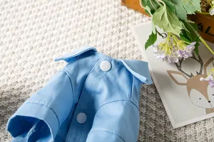 Gros plan d'une chemise en jean bleu clair pour animaux avec boutons-pression blancs