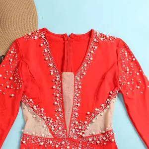Dettaglio di tuta rossa sexy con perle bianche e accenti di strass molto scintillanti.