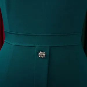 Gros plan sur la taille d'une robe sarcelle élégante avec bouton décoratif