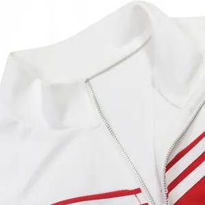 Detailopname van de opstaande kraag en metalen rits op een wit-rood sportief topje