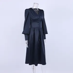 Elegante marineblauwe satijnen theejurk met lantaarnmouwen en V-hals op een mannequin