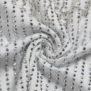 Detailed macro view of white fabric with sparkling silver rhinestone embellishments