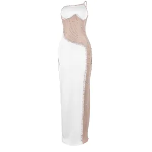 Vista dettagliata di un abito lungo bianco con sexy strass e decorazioni in rete di perle