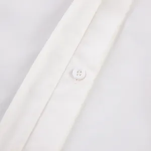 Close-up detail of a white cotton shirt showing a neat button and placket stitching.