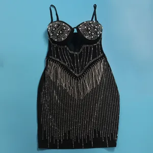 Detailed view of black bodycon dress with pearls, rhinestones, and dangling tassels.