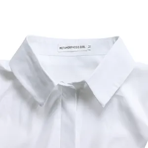 Vista de cerca del cuello de camisa blanca con etiqueta Metamorphosis Girl talla M