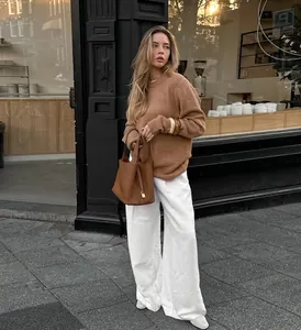 Full look detail of high-waisted white wide-leg trousers in a casual street setting