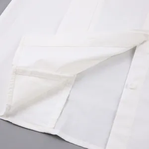 Detailed close-up view showing high-quality stitching on white cotton shirt hemline