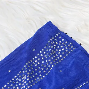 Detailed view of royal blue evening dress with sparkling rhinestone craftsmanship.