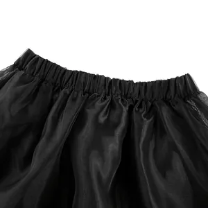 Dettaglio della vita elastica su una gonna di tulle nero con trama delicata