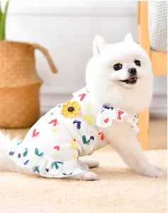 Nahaufnahme des weißen Hunde-Sommerkleides mit bunten Herzchen und Sonnenblume.