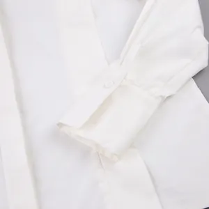 Close-up of white cotton shirt cuff showing clean stitching and single button detail