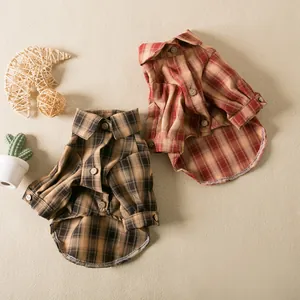 Two classic plaid pet shirts in red and brown colors for small dogs and cats on a beige surface