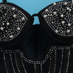 Close-up of intricate pearl and rhinestone details on a black women's party dress