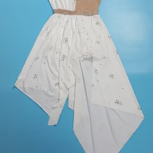 Dettaglio di una tuta bianca senza maniche con strass e gonna asimmetrica in rete.