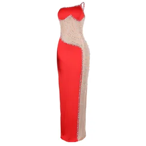 Dettaglio di un abito da sera rosso sexy con inserti in mesh trasparente e perle