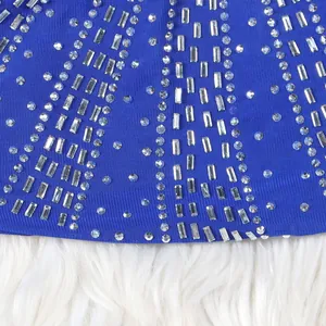 Close-up detail of sparkling silver rhinestones on elegant royal blue evening dress fabric