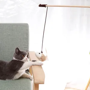 Close-up detail of interactive cat teaser wand with wooden pole and burlap mouse toy