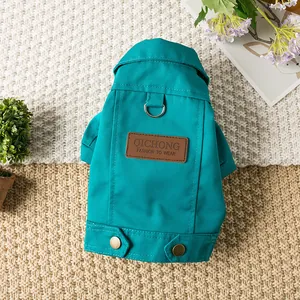 Détail rapproché d'une veste sarcelle pour animaux avec écusson en cuir et anneau en D