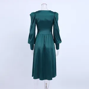 Achteraanzicht van elegante groene satijnen jurk met lange lantaarnmouwen en taille