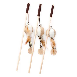 Close-up of linen ball cat teaser stick with natural feathers and wooden pole.