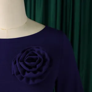 Détail d'une élégante rose en tissu 3D sur une robe violette grande taille pour femmes