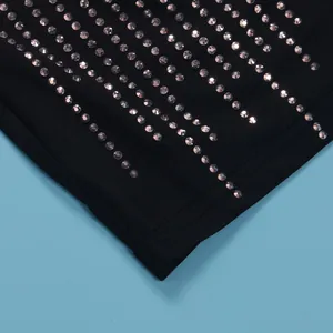 Detailed close-up showing rows of sparkling silver rhinestones on black elastic fabric.