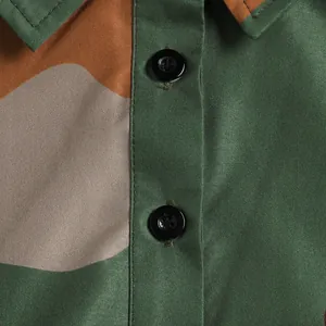 Close-up of the camouflage fabric and black button details on a lapel dress.