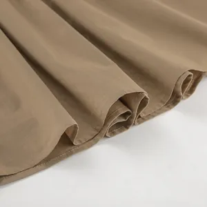 Close-up of khaki cotton linen fabric texture and hem of a French style A-line skirt