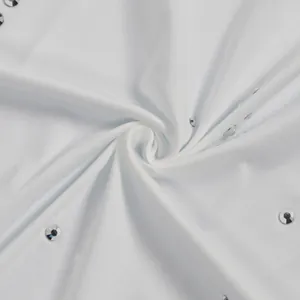 Dettaglio ravvicinato di tessuto bianco elasticizzato con strass argento brillanti