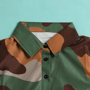 Detailed macro view of a camouflage print dress featuring a pointed lapel and buttons.