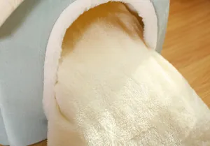 Close-up detail of soft cream-colored plush lining in a warm pet cave bed