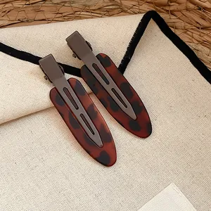 Detailaufnahme von Haarklammern aus Acryl mit Leopardenmuster und braunem Metallclip.