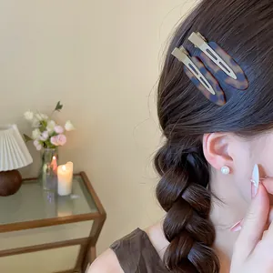 Nahaufnahme stilvoller brauner Acryl-Haarspangen mit Schildpattmuster im geflochtenen Haar
