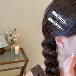 Detailaufnahme von zwei Vintage-Schildpatt-Haarspangen aus Acryl in geflochtenem braunem Haar
