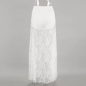 Détail du motif floral en dentelle blanche transparente sur une jupe longue.