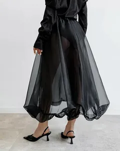 Vista posteriore di elegante gonna a palloncino nera in tulle velato con top in seta