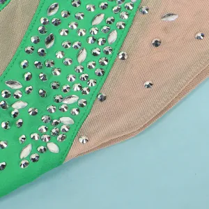 Detailed macro shot of shimmering rhinestones on green and nude mesh dress fabric