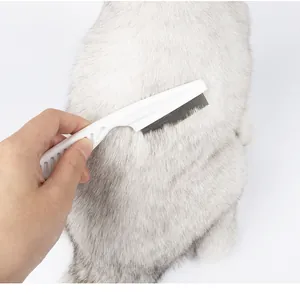 Action shot of fine-tooth pet flea comb brushing through silver cat fur for grooming