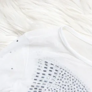 Close-up detail of white sheer mesh fabric with shiny silver rhinestone embellishments
