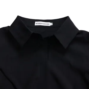 Detalle del cuello de un elegante vestido negro de manga larga con etiqueta de marca