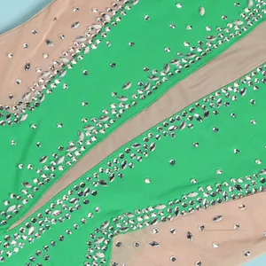 Detailed macro view showing silver rhinestones on green and nude mesh evening gown fabric