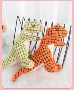 Close-up detail of orange and green squeaky plush dinosaur dog toys with textured fabric