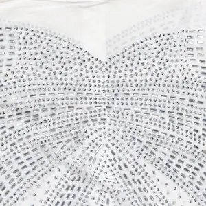 Detailed view of shimmering rhinestone embellishments on a white evening gown.
