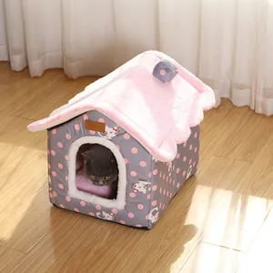 Cozy house-shaped cat bed featuring pink polka dots and a warm plush interior lining
