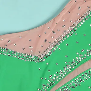 Detail view of sparkling silver rhinestones and sheer mesh panels on a green evening dress