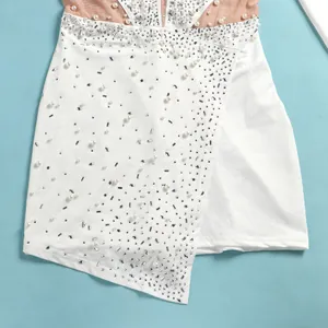 Dettaglio di una tutina bianca con eleganti perle e brillanti decorazioni in strass