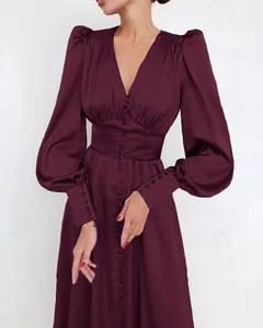 Elegante bordeauxrode satijnen jurk met lantaarnmouwen en knoopsluiting aan de voorkant.